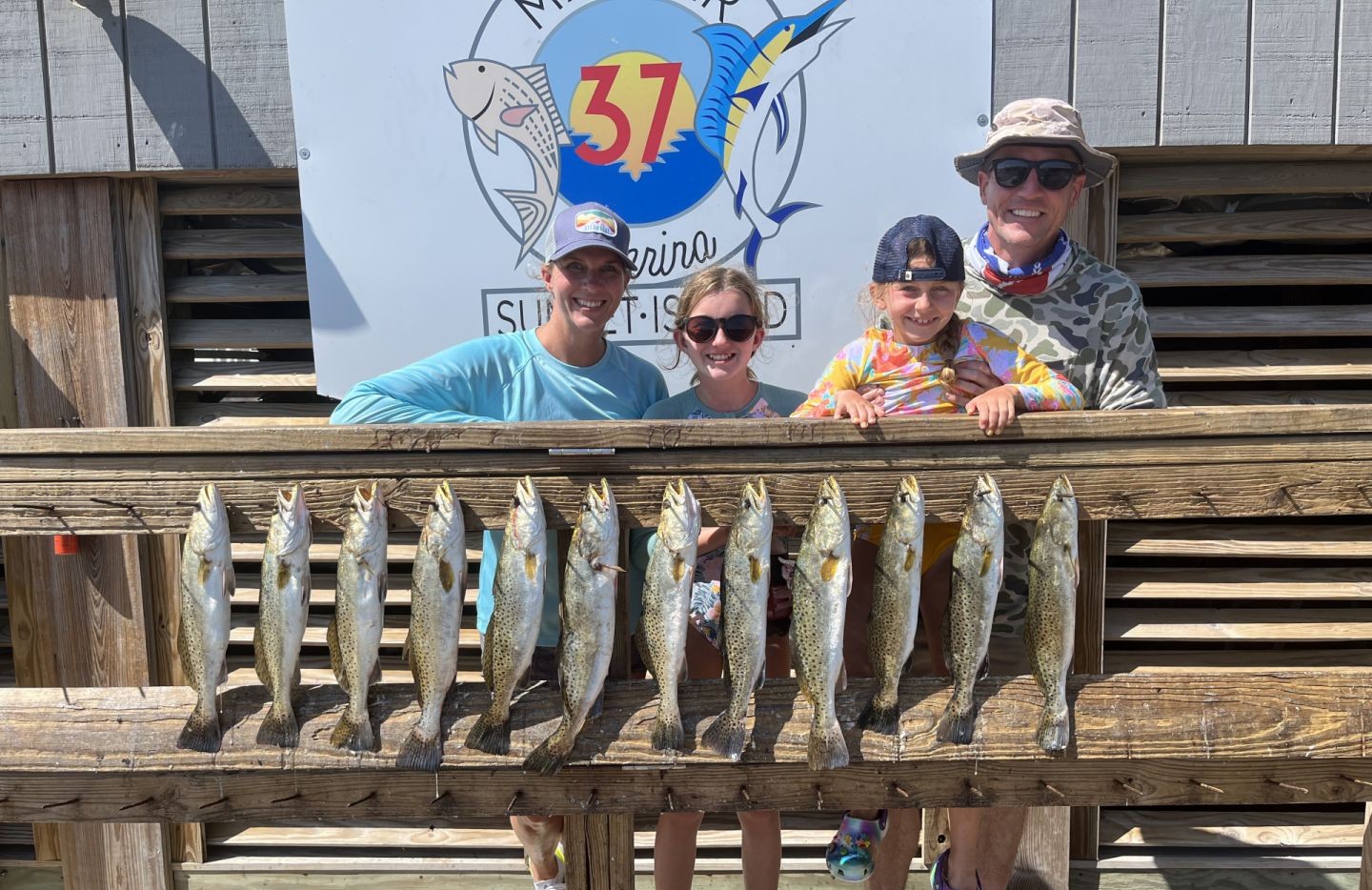 Twelve speckled trout caught fishing in Aransas Pass TX displayed on wooden dock railing