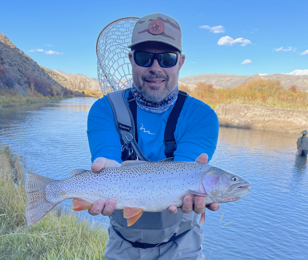 A fisherman with a large rainbow trout caught while fishing in Cokeville