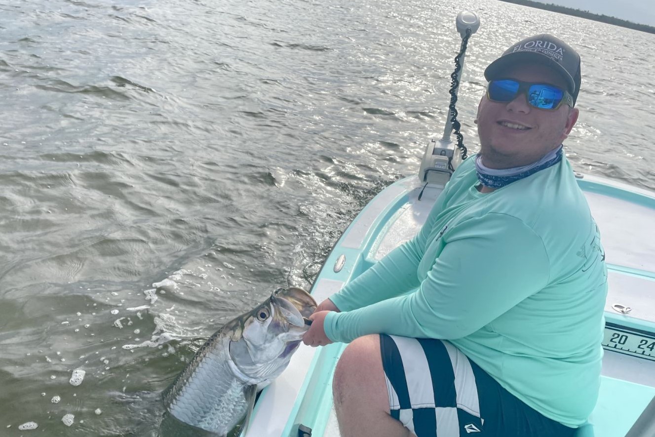 A fisherman holding a tarpon in the Everglades City