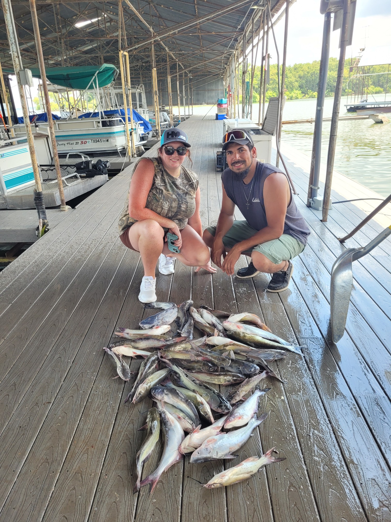 Successful fishing trip displaying large catch of multiple fish species on wooden dock at West Tawakoni TX marina