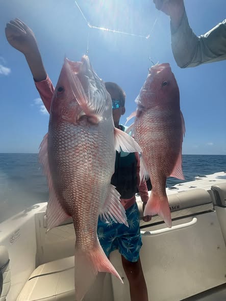 Two red snapper caught fishing in Corpus Christi TX displayed on boat deck