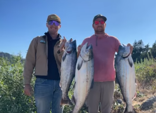 Two anglers displaying their catch of Chinook salmon in Grants Pass, Oregon