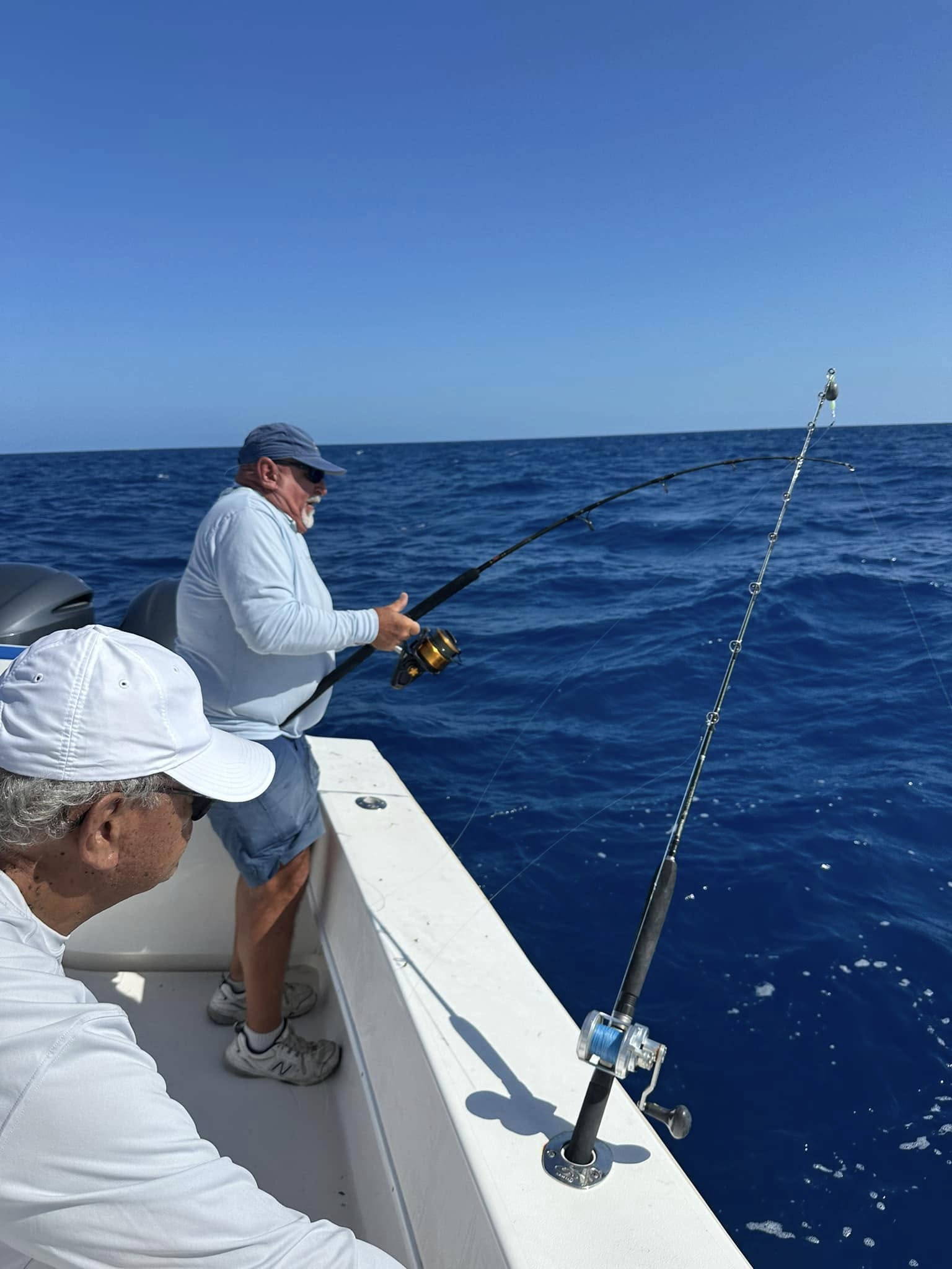 Deep sea fishing from boat with multiple fishing rods in blue ocean waters near Little Torch Key FL