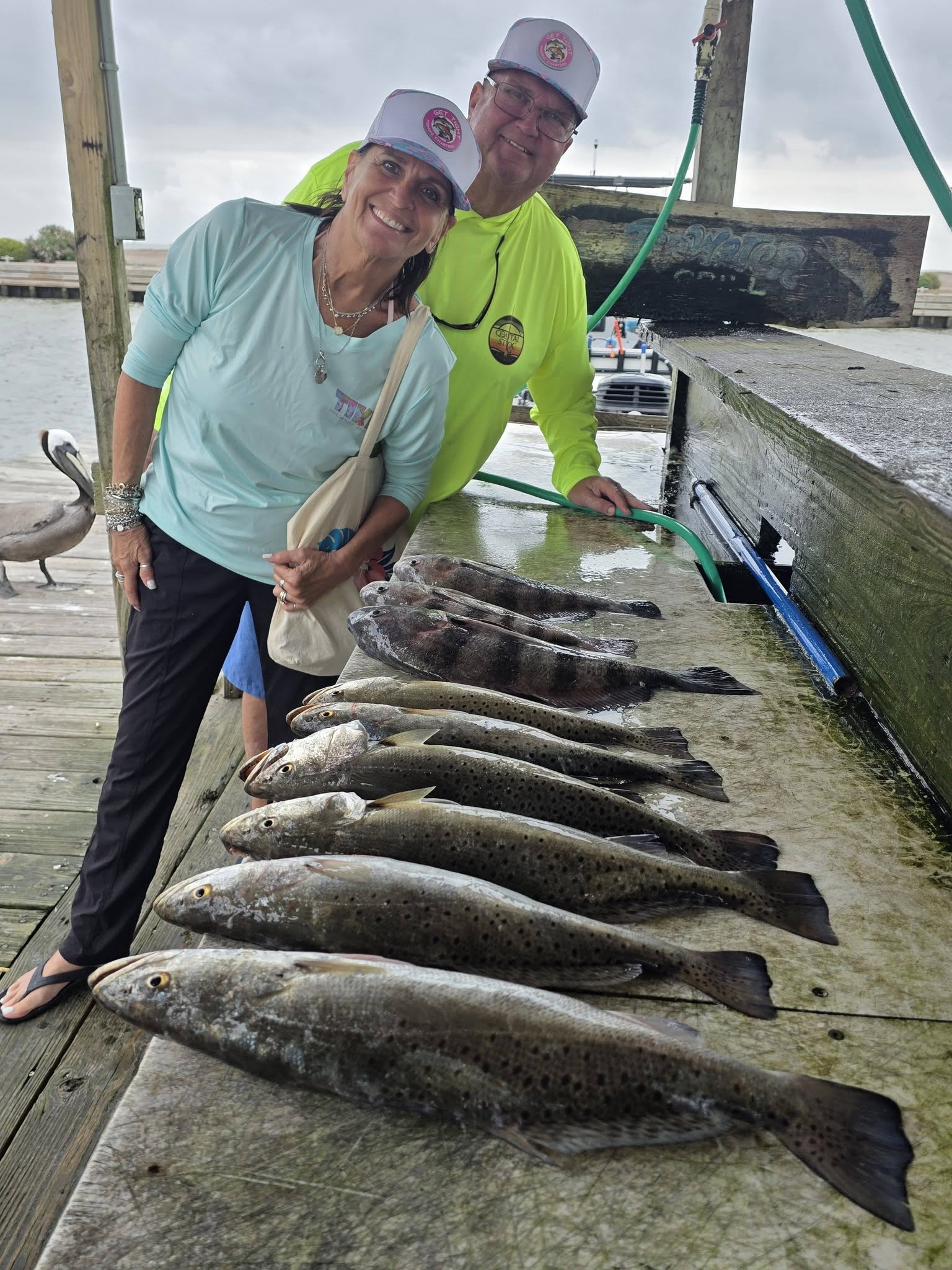 Successful fishing trip in Texas City TX showing speckled trout and black drum catch laid out on wooden dock