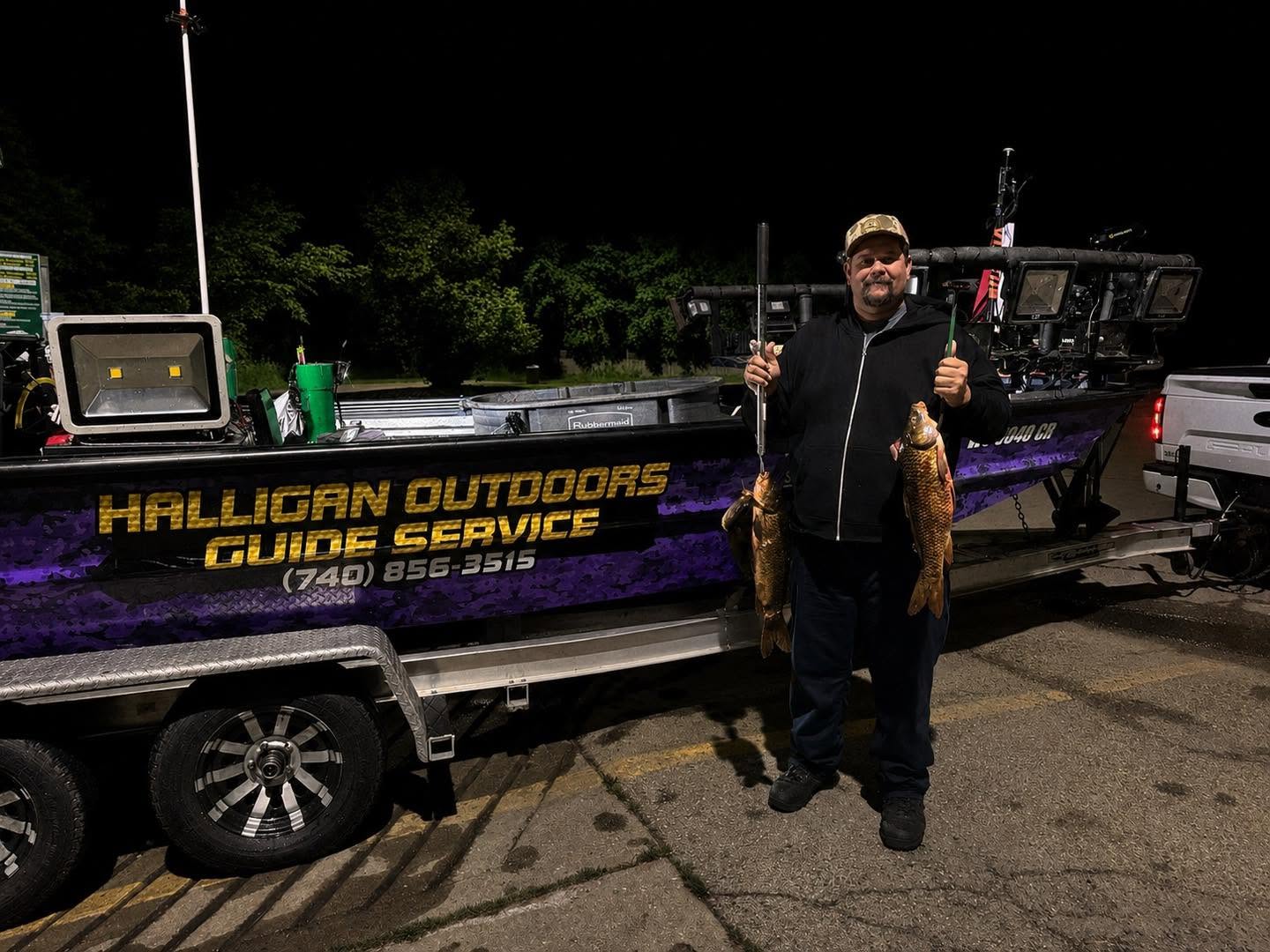 Fishing guide holding catch at boat ramp in Delavan WI at night