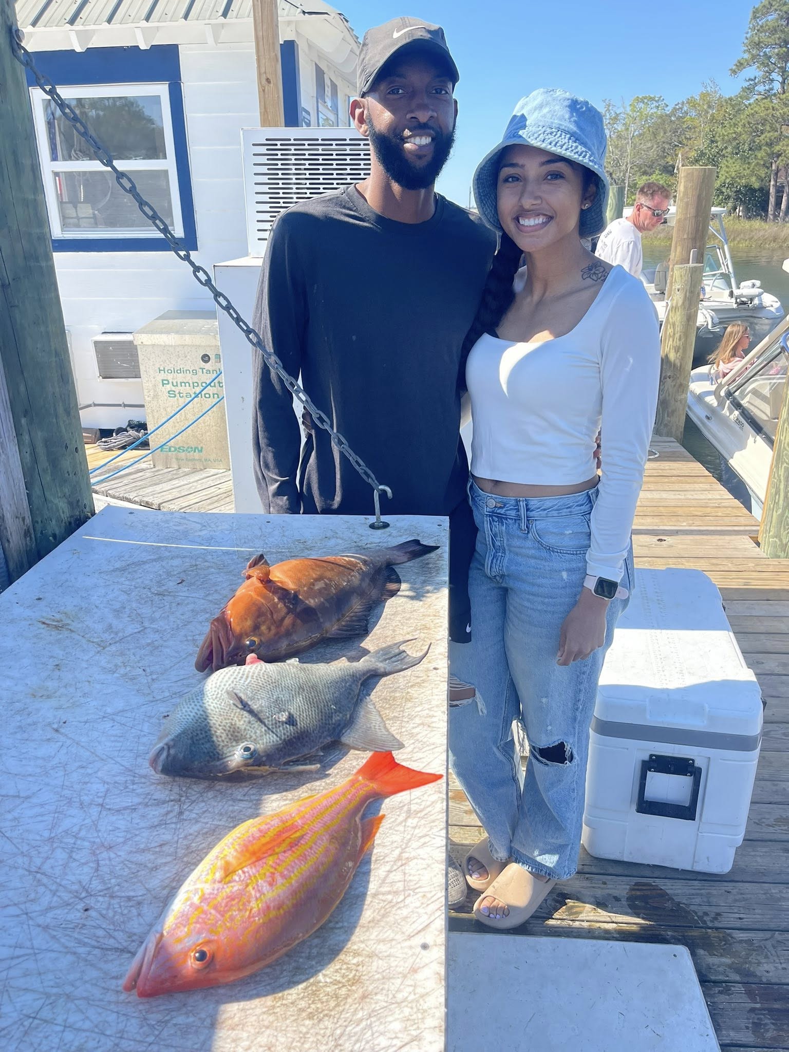 Fresh caught lane snapper, red grouper, and grey triggerfish displayed on cleaning station dock in Niceville FL
