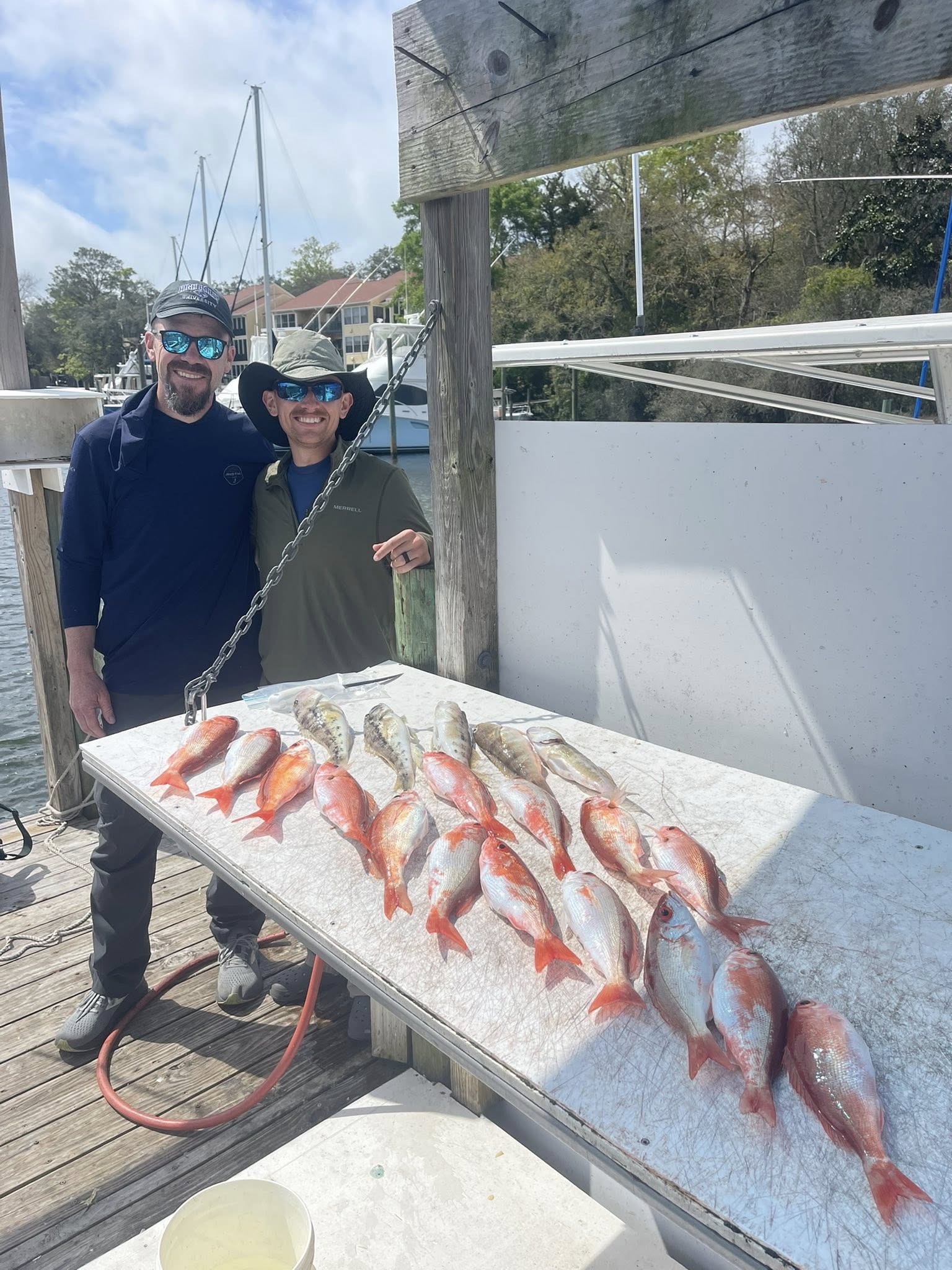 Fresh caught red snapper and grouper displayed on cleaning table at marina dock in Niceville FL