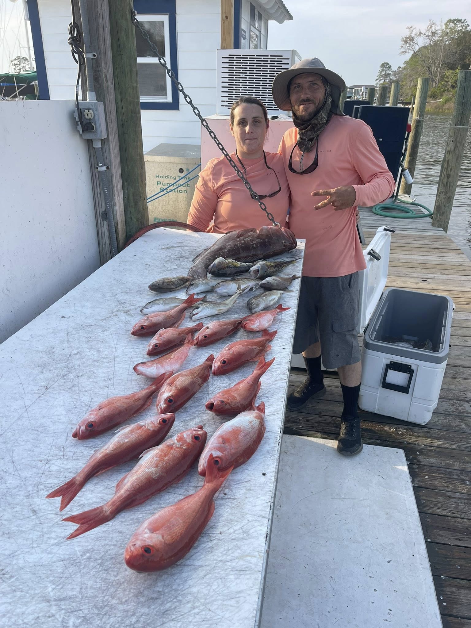Fresh caught red grouper and other fish species displayed on cleaning table at Niceville FL fishing dock