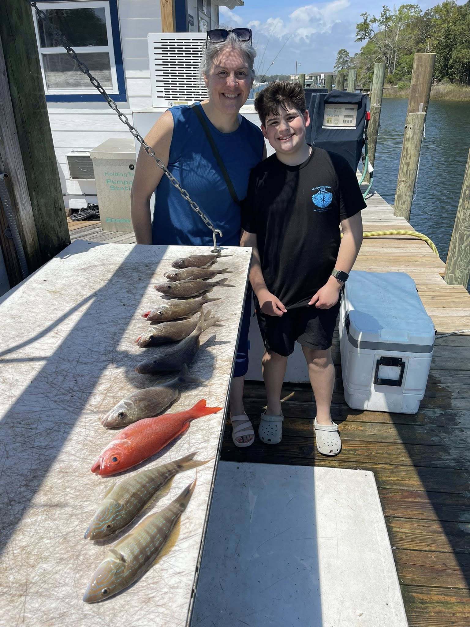 Fresh caught sand perch and other fish displayed on cleaning table at Niceville FL dock
