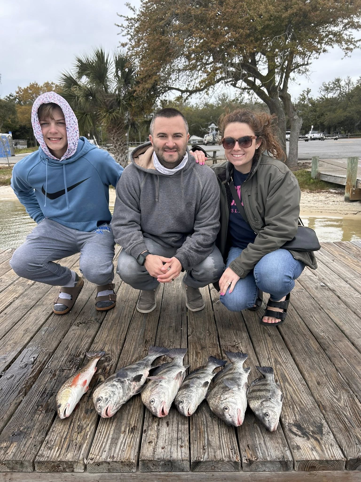 Successful fishing trip in Pensacola FL showing caught redfish and black drum on wooden dock