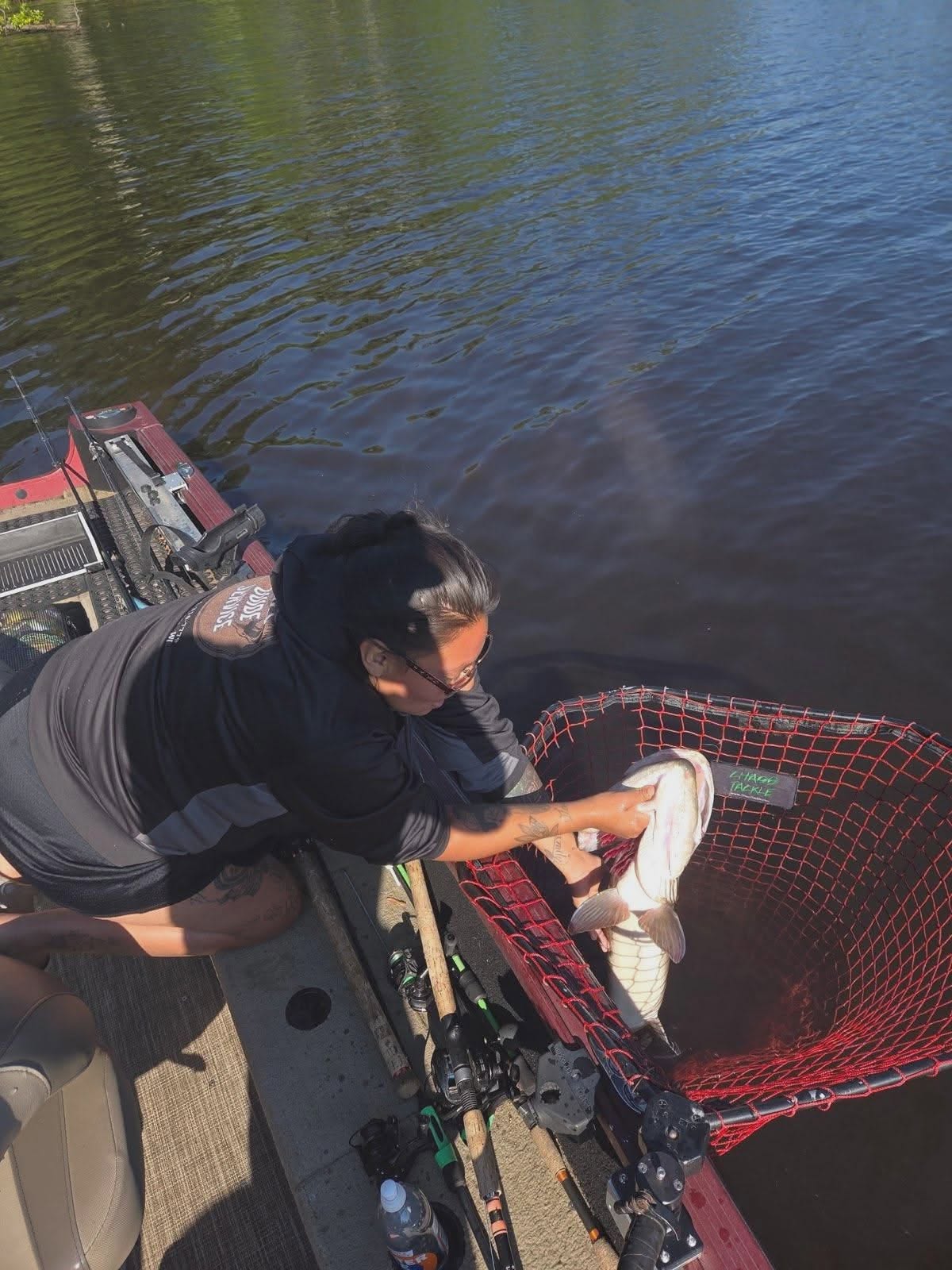 Angler landing fish in red landing net on boat in Mosinee WI