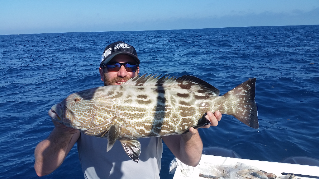 Angler holding a 28-inch fish in the tropical waters of Key West