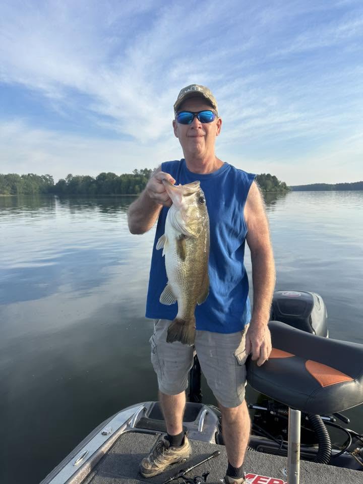 Angler holding freshly caught bass on fishing boat in Moncure NC