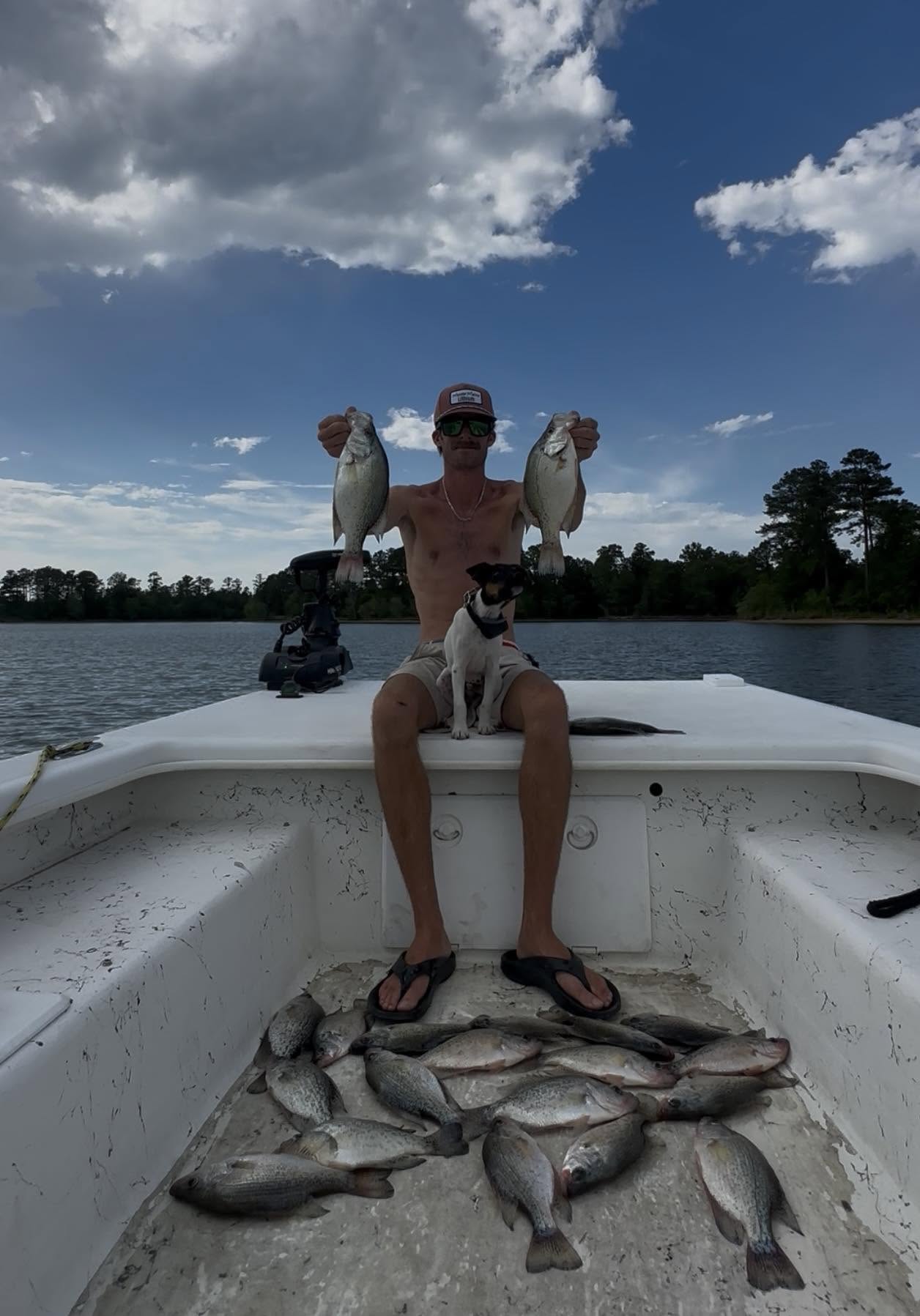 Successful fishing trip in Moncure NC showing caught crappie and white bass on boat deck with dog