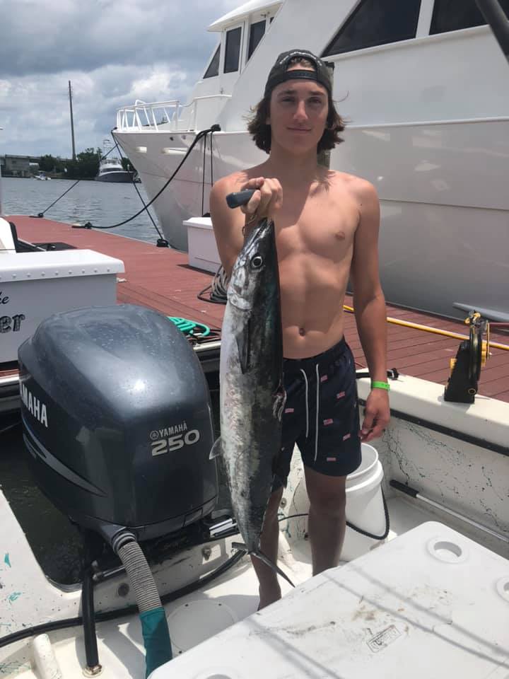 Proud angler holding a large king mackerel caught at Wrightsville Beach