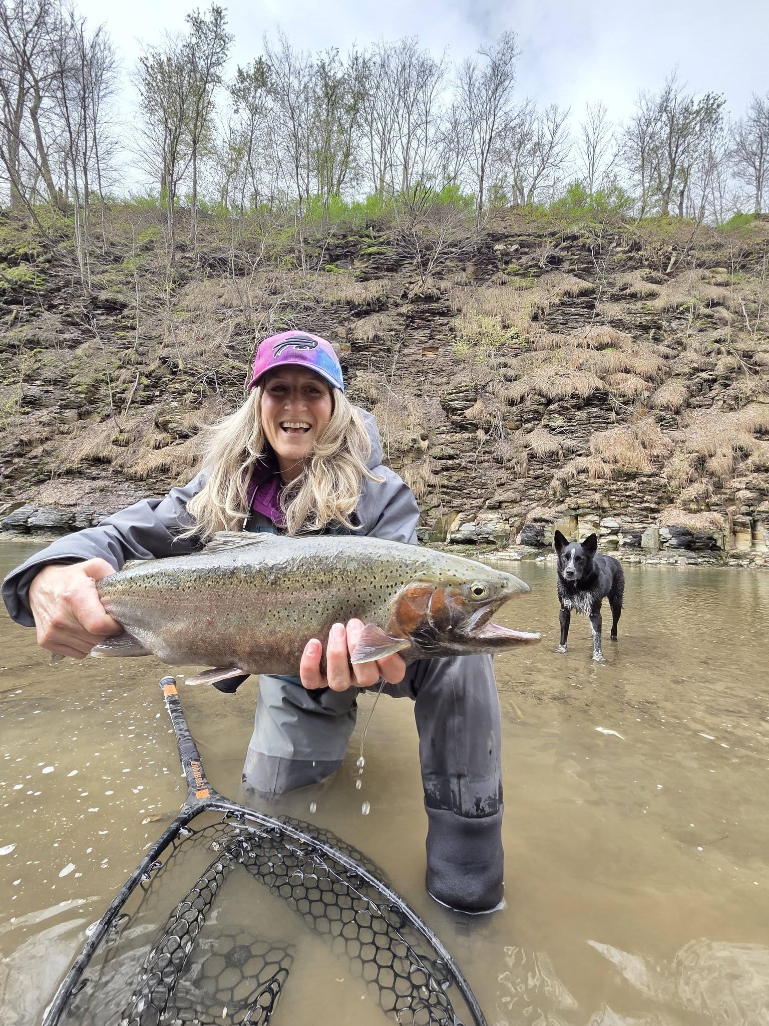 Rainbow trout catch in Angola NY with fishing net and dog in background