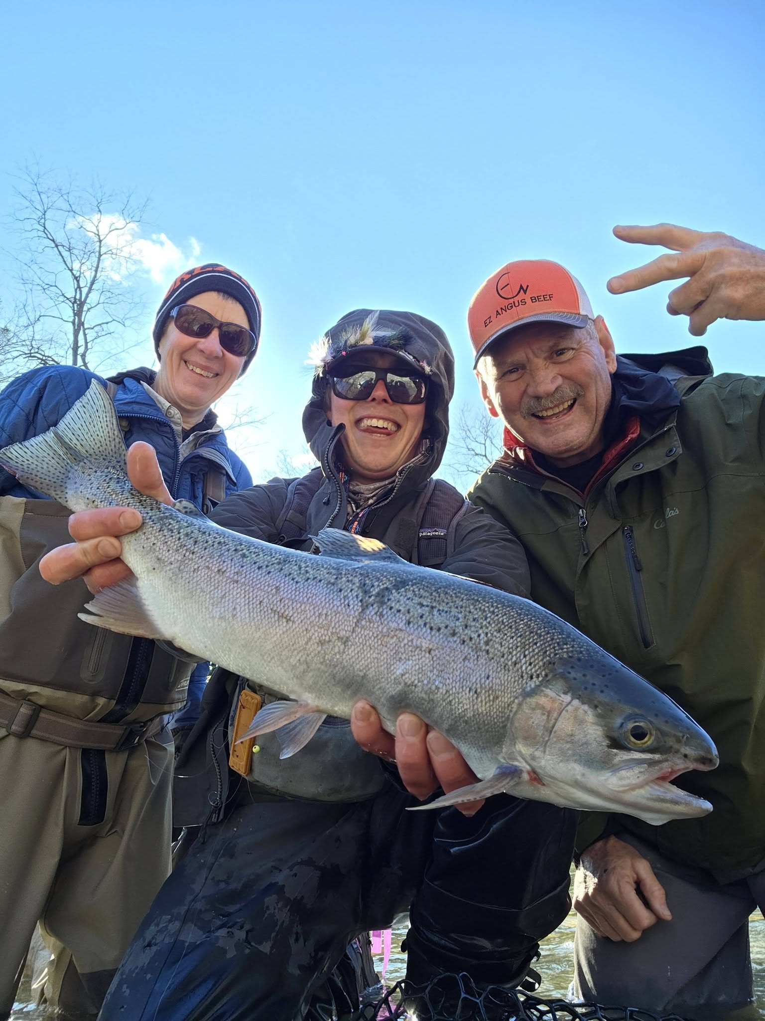 Three anglers holding large rainbow trout caught in Angola NY