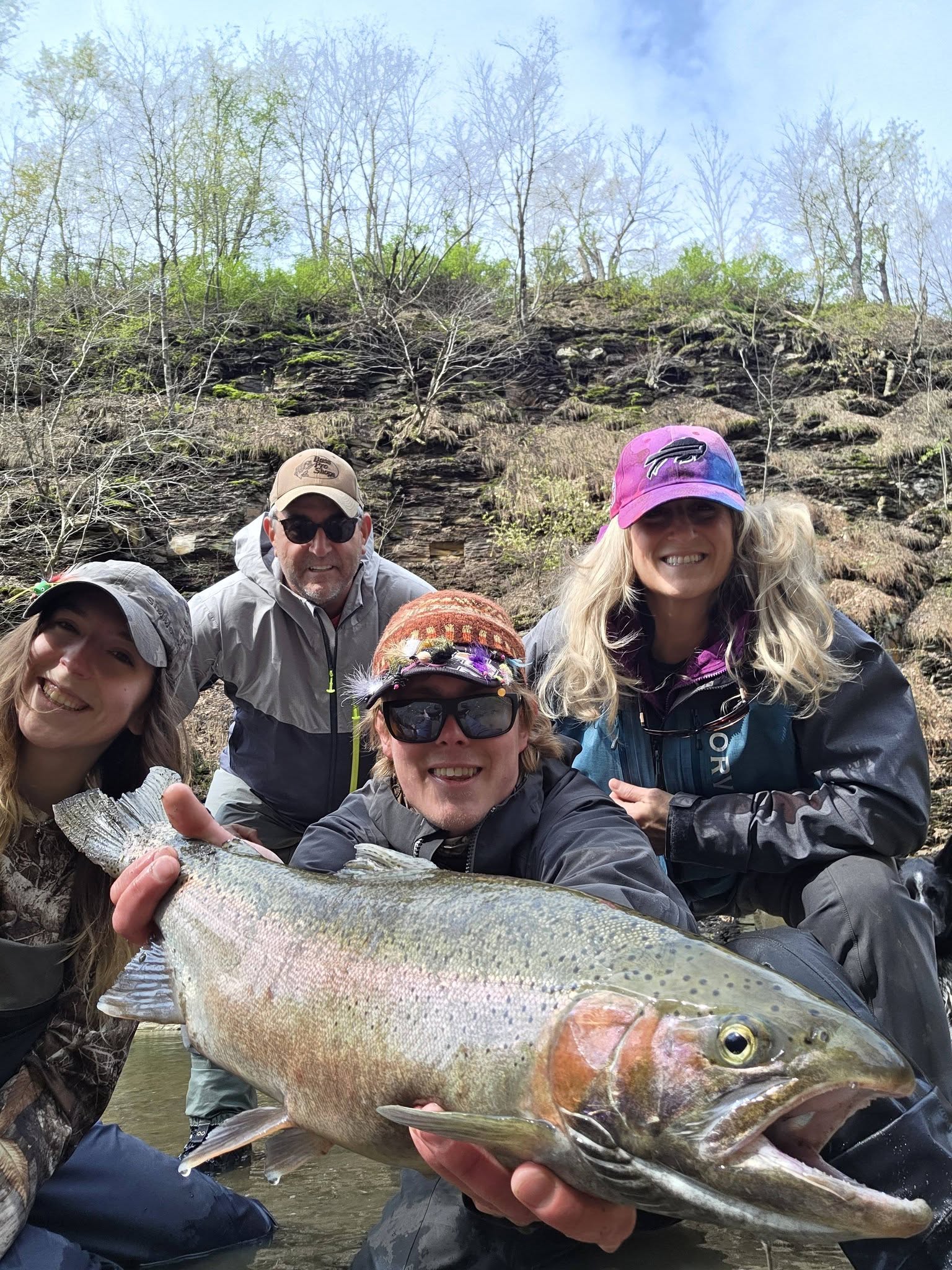 Rainbow trout caught while fishing in Angola NY with excited anglers celebrating the catch