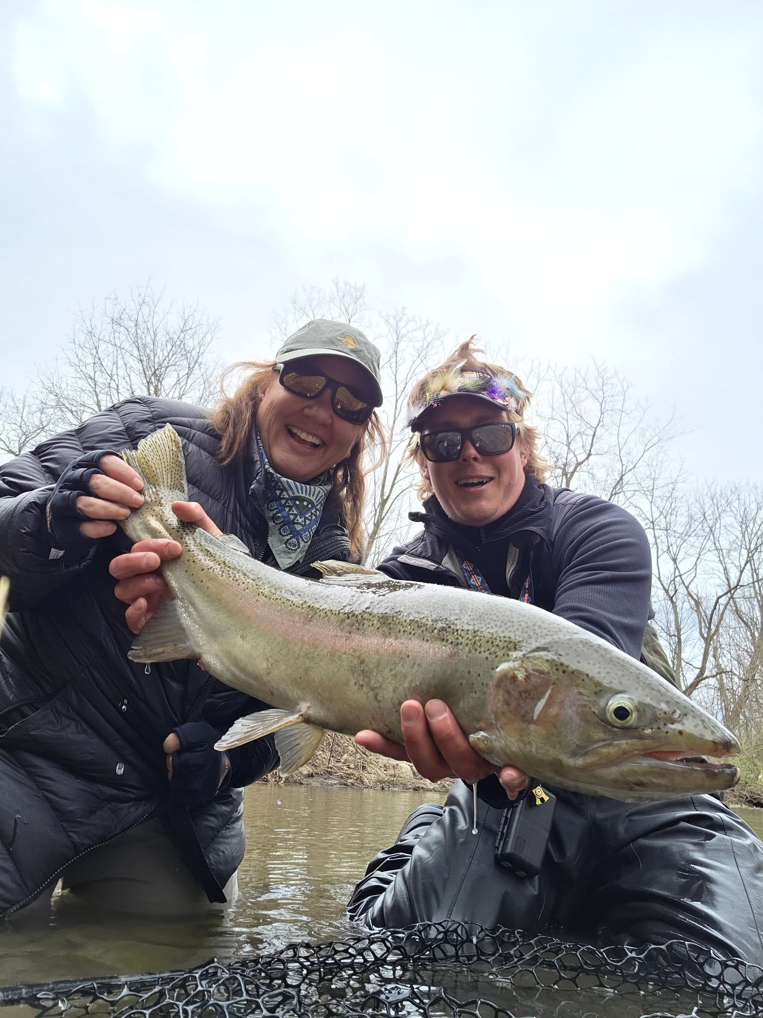 Two anglers holding large steelhead trout catch in Angola NY fishing waters