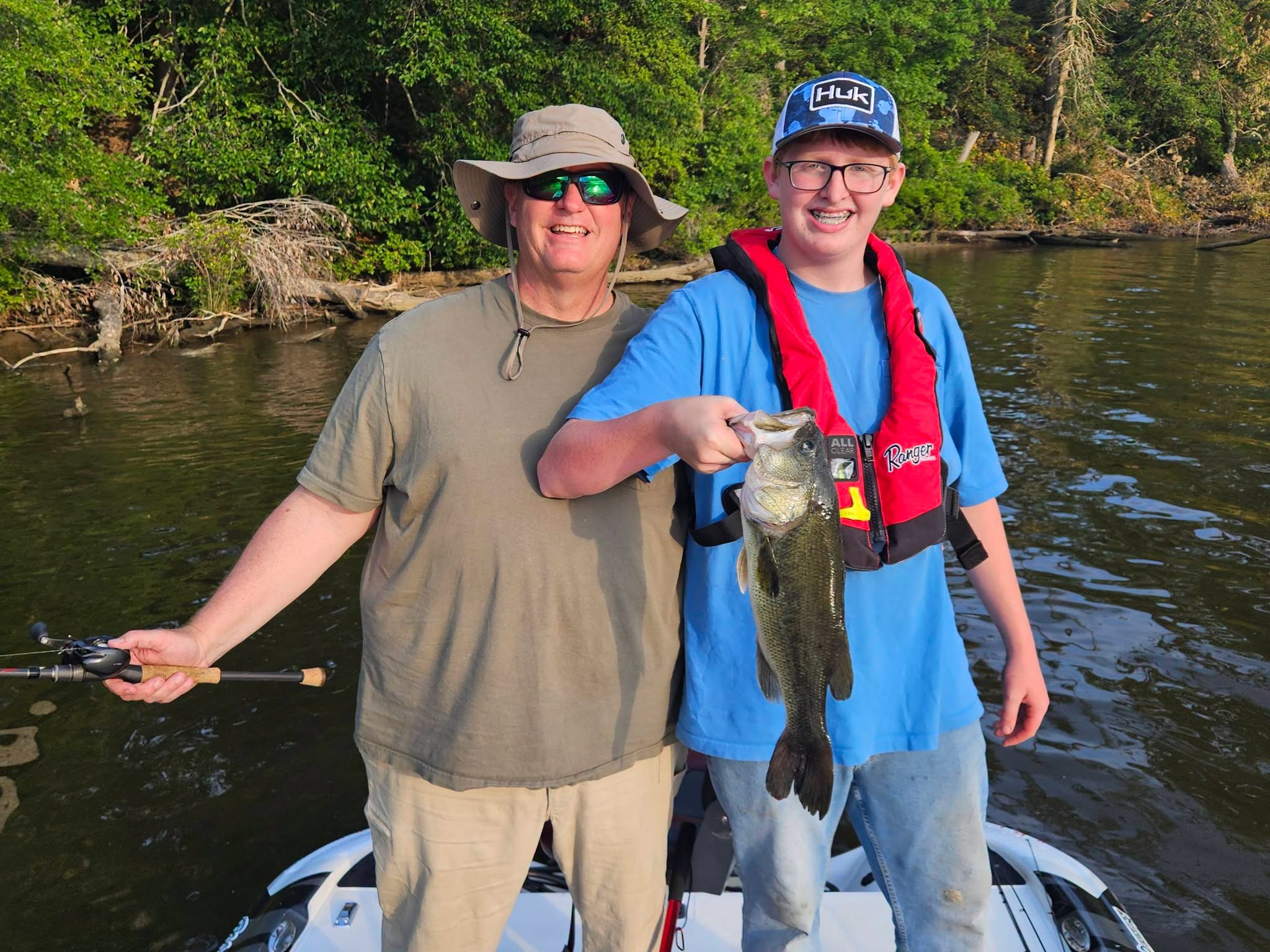 Two anglers on boat displaying caught bass fish in King George VA