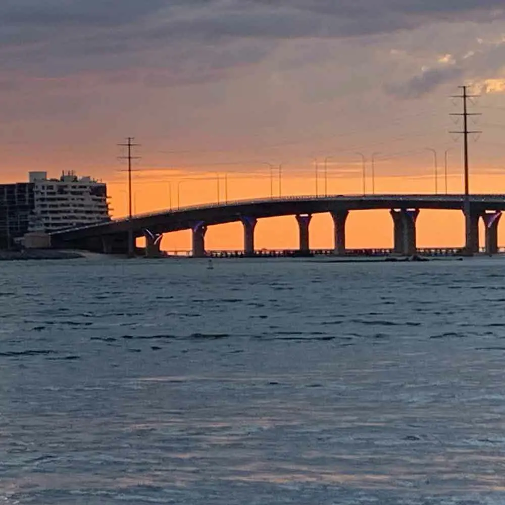 Virginia Beach sunset cruise boat on coastal waters with golden sky and shoreline views