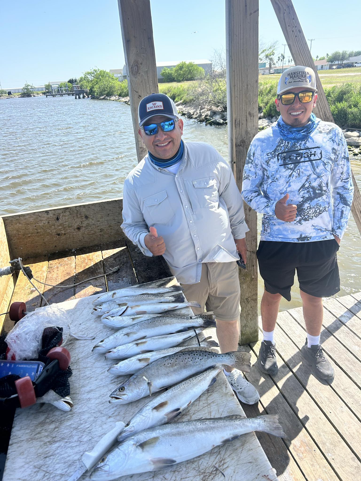 Successful speckled trout fishing trip on wooden dock in Corpus Christi TX with large catch displayed