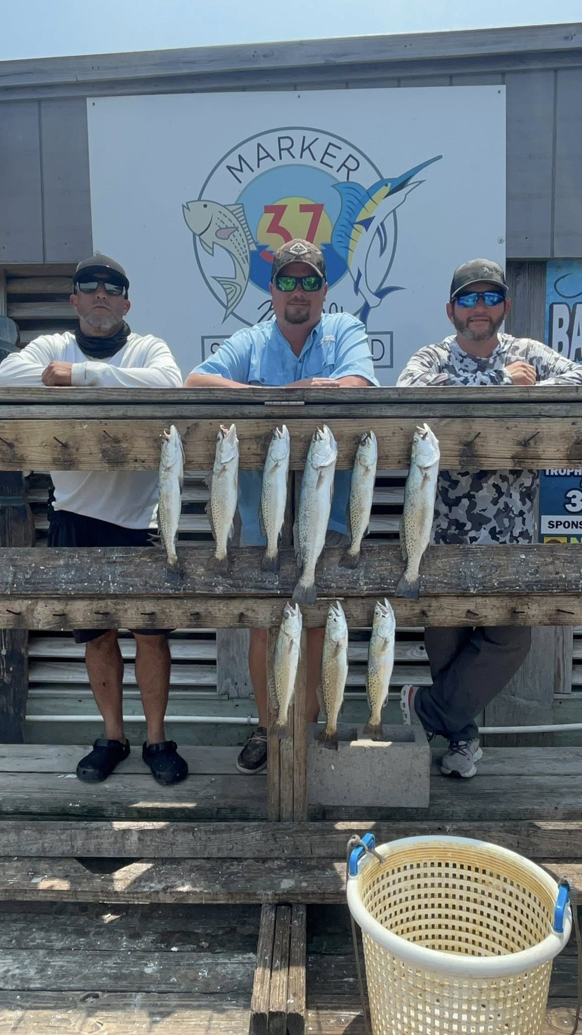 Eight speckled trout displayed on wooden dock after successful fishing trip in Corpus Christi TX