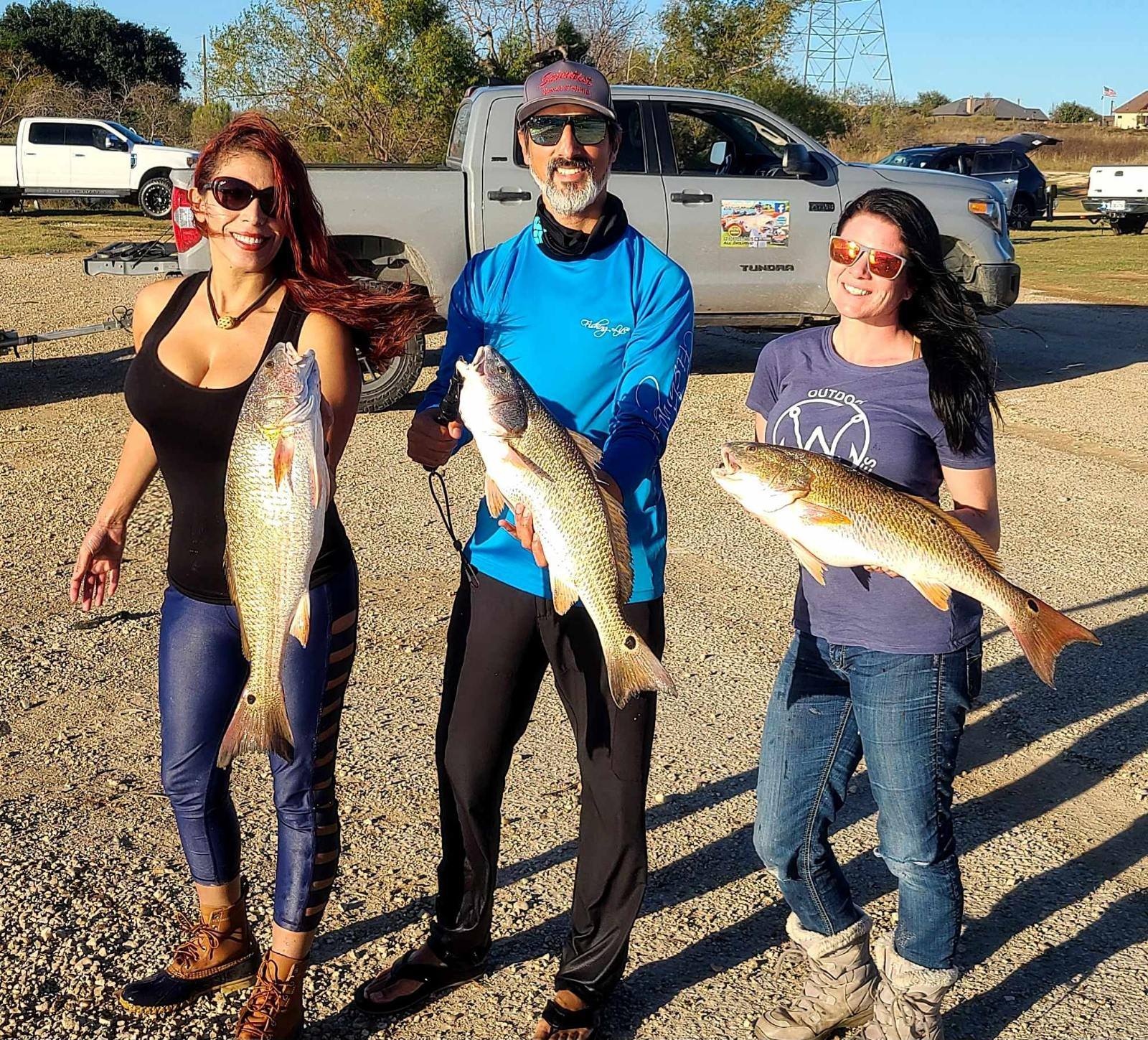 Three redfish caught during fishing trip in San Antonio TX displayed on pavement