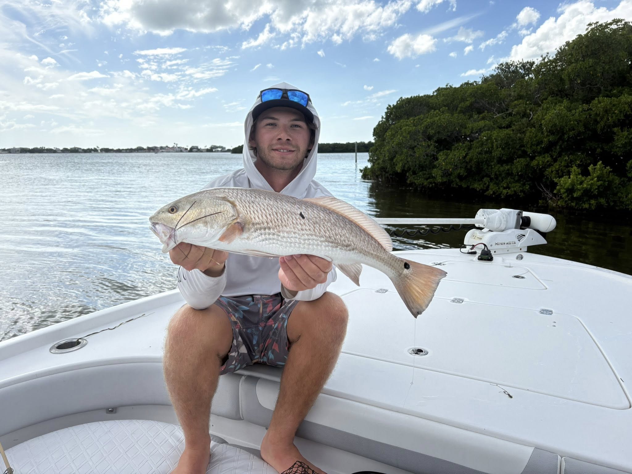 Tampa Bay inshore fishing charter boat with anglers catching snook and redfish at sunrise