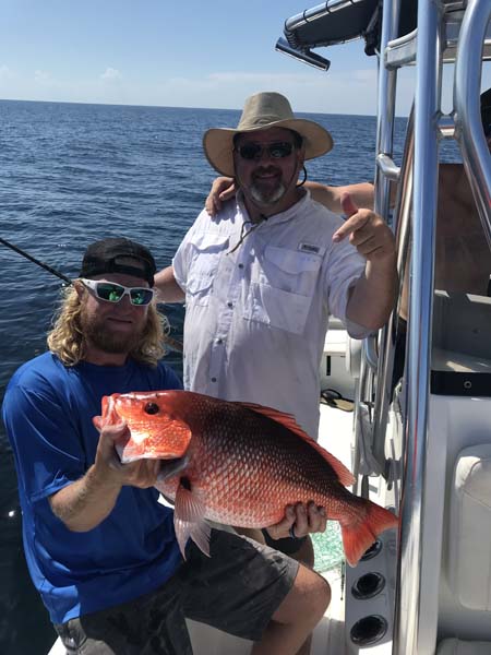 Two people holding a fishing rod in Destin