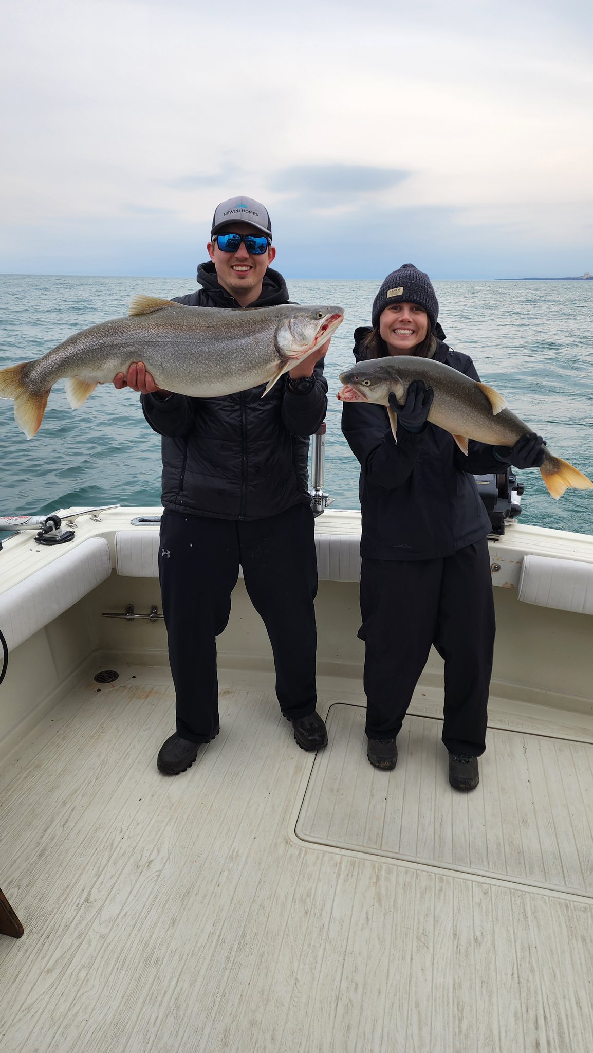 Two lake trout caught during fishing trip in Olcott NY displayed on boat deck
