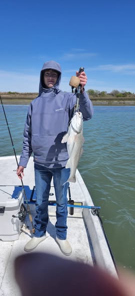 Angler holding caught fish on boat in Port O'Connor TX waters