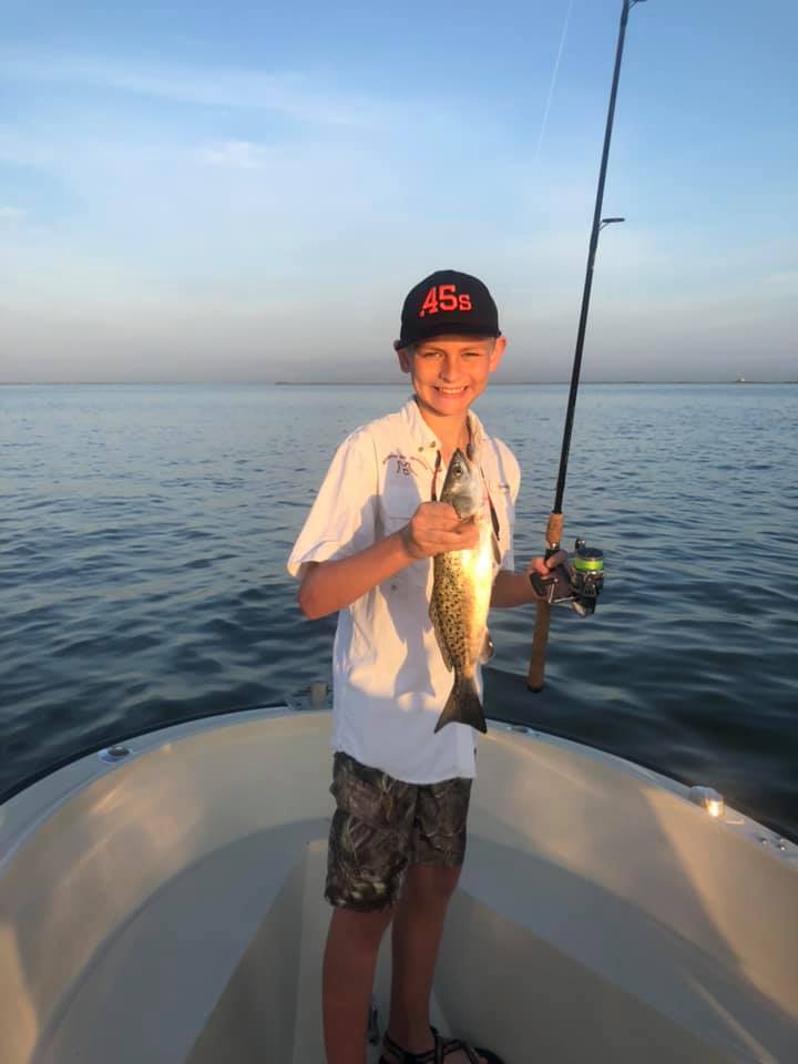 Fisherman holding 15-inch catch in Galveston