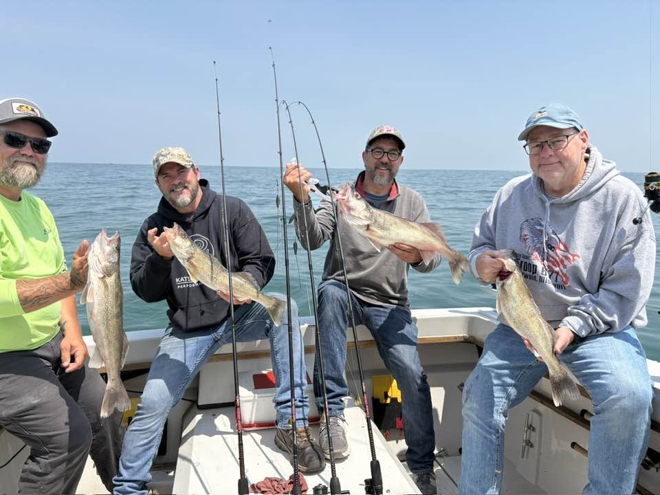 Four anglers displaying fresh caught walleye on fishing charter boat in Port Clinton OH