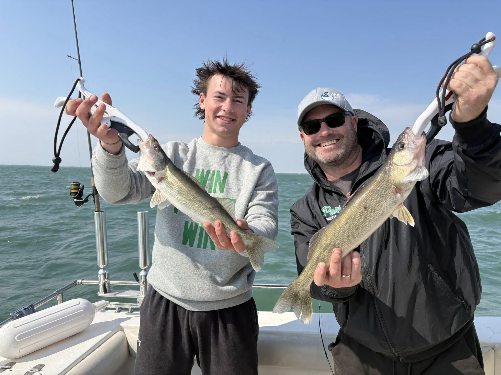 Two anglers displaying freshly caught walleye on fishing boat in Port Clinton OH waters