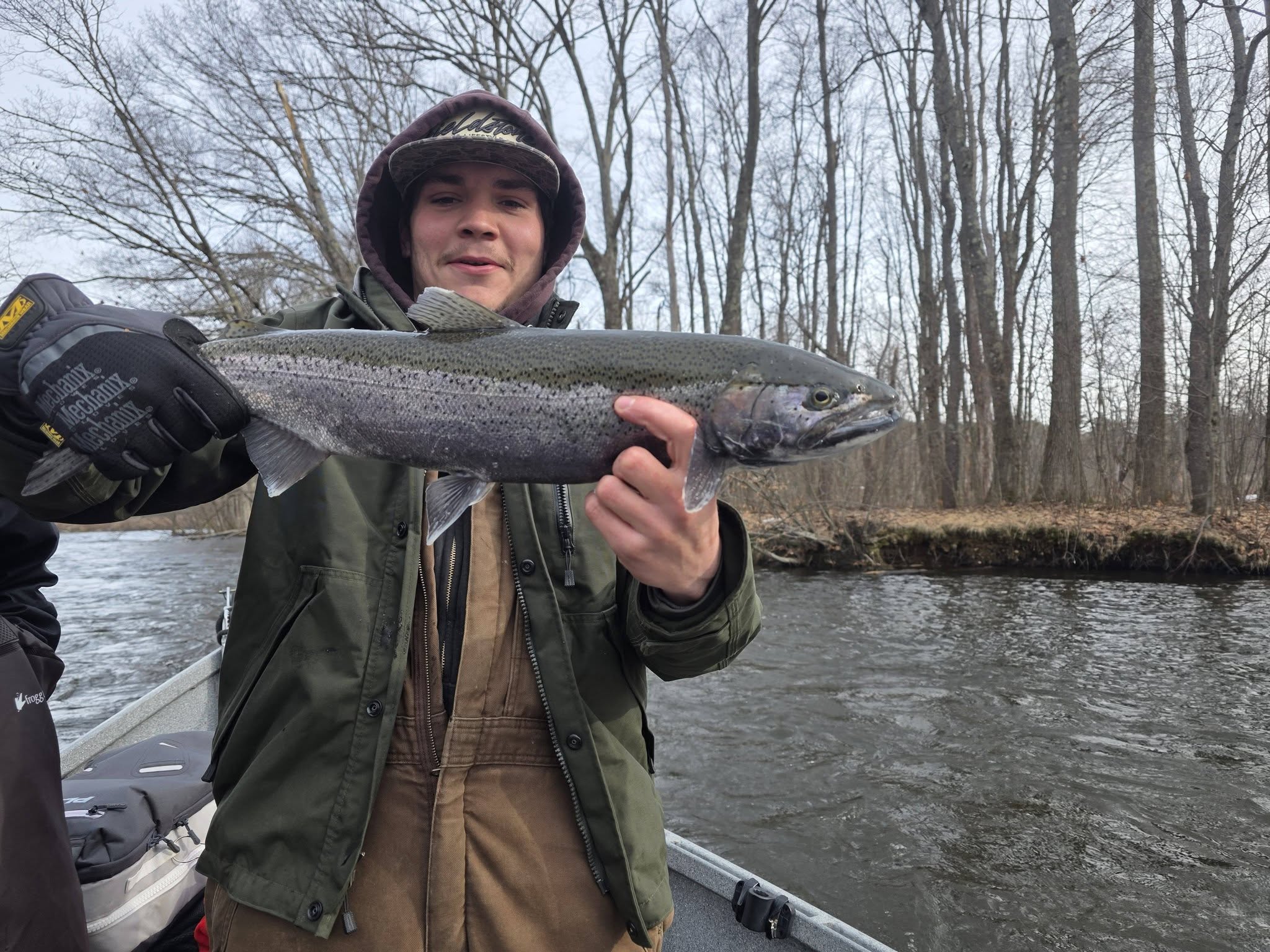 Coho salmon caught while fishing in Ellisburg NY on river with bare trees in background