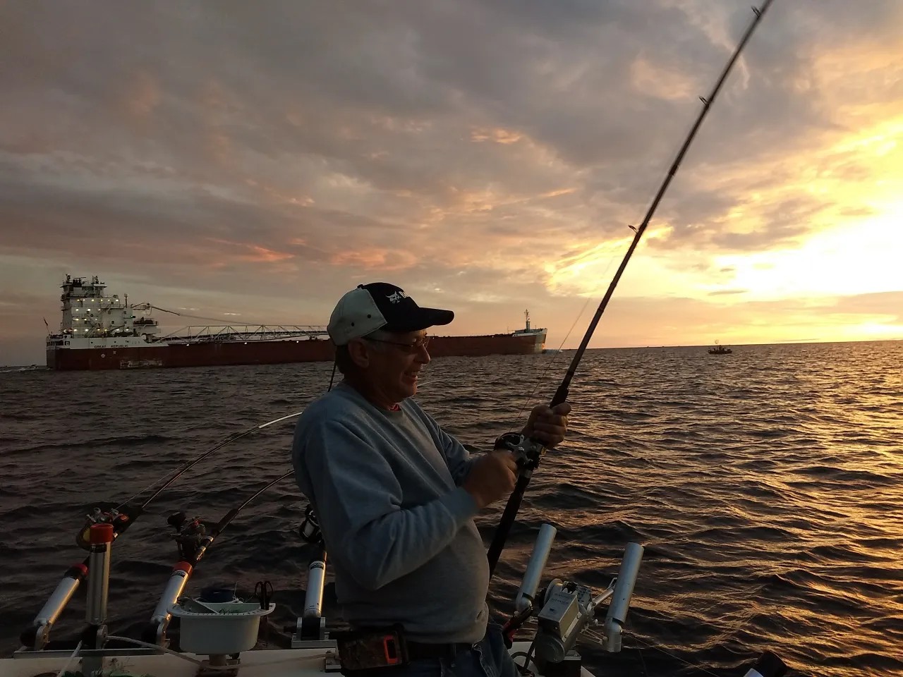 Fishing at sunset in Manistee MI with cargo ship in background