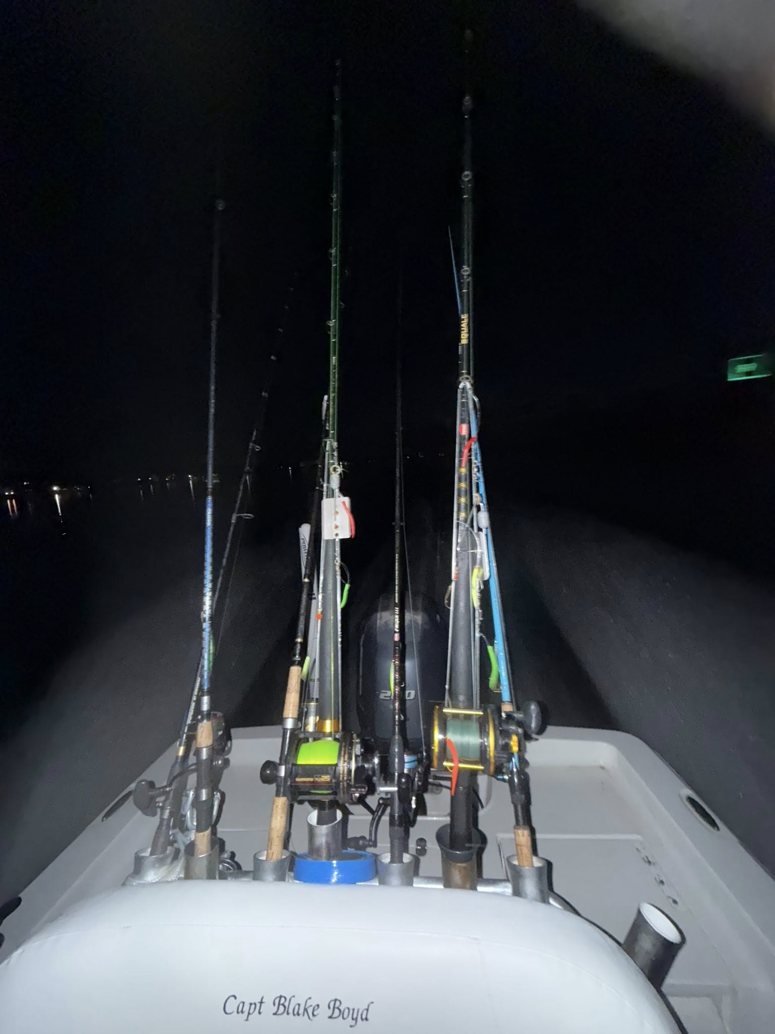 Fishing rods and reels set up on boat deck at night in Surf City NC for fishing charter