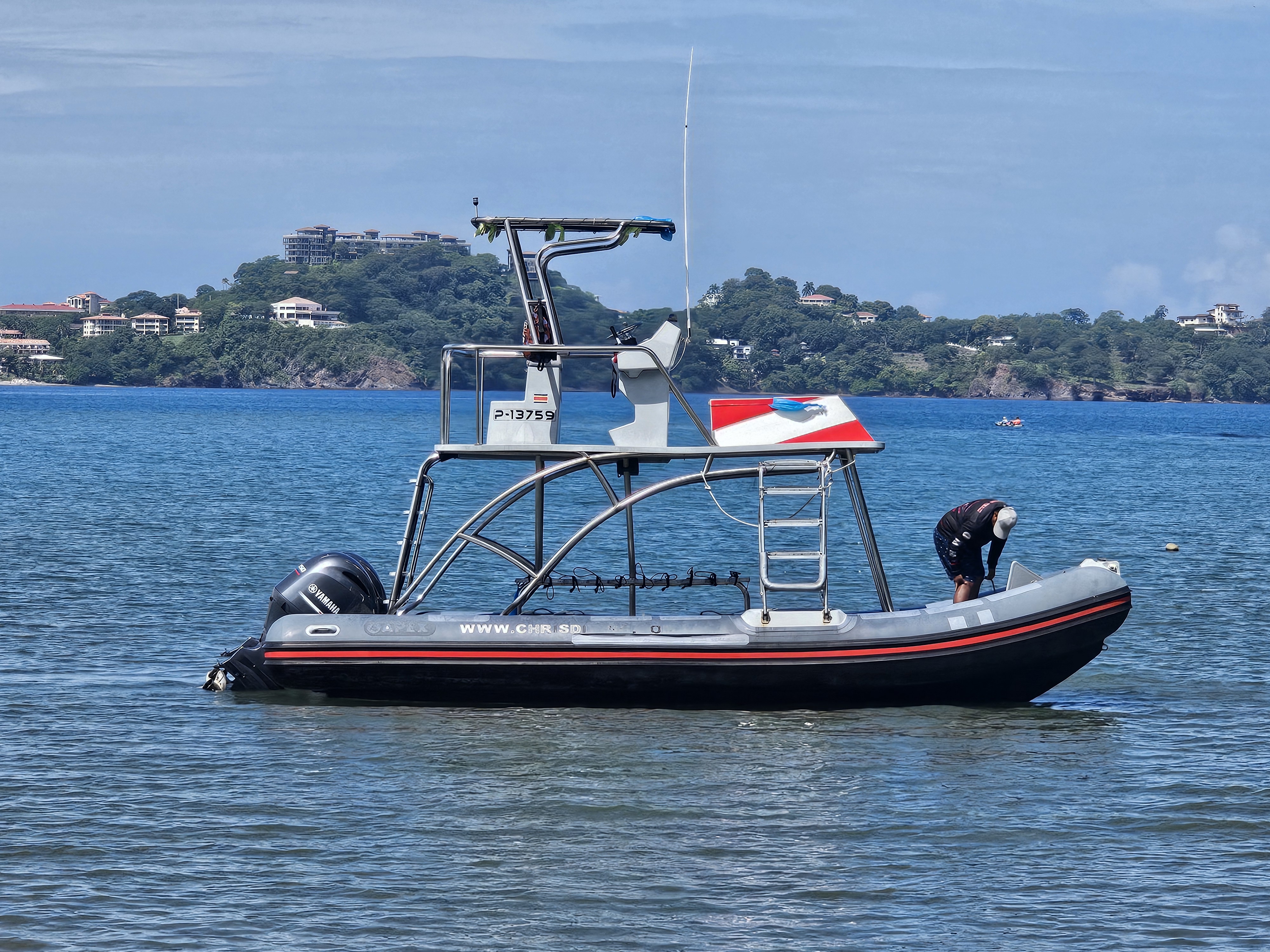Coast Guard patrol boat on blue water near Spring Hill FL coastline with forested hills in background
