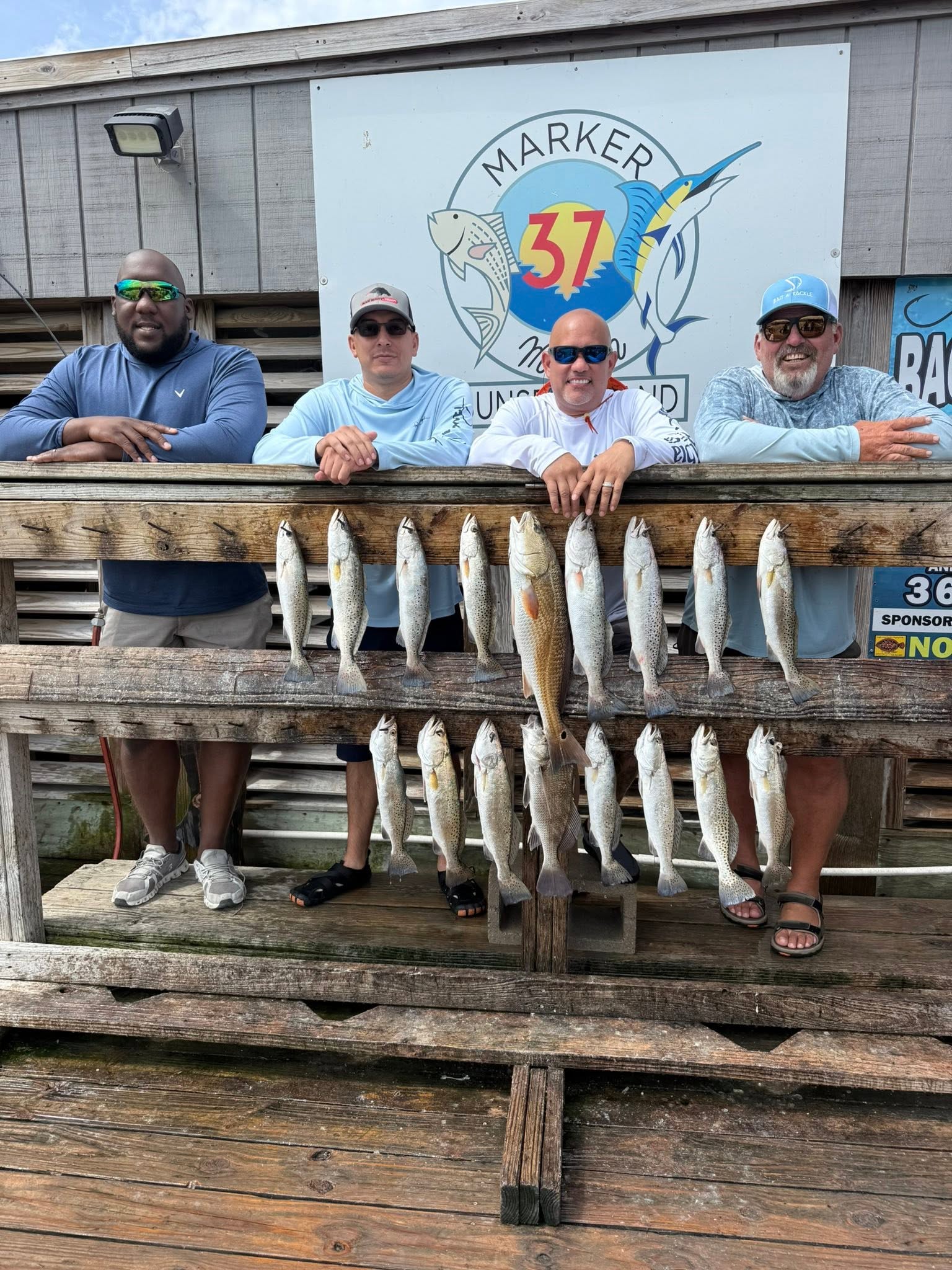 Successful speckled trout fishing trip with multiple fish displayed on wooden dock in Corpus Christi TX