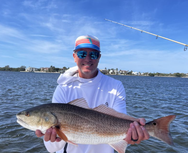 Angler holding a large redfish in Holmes Beach