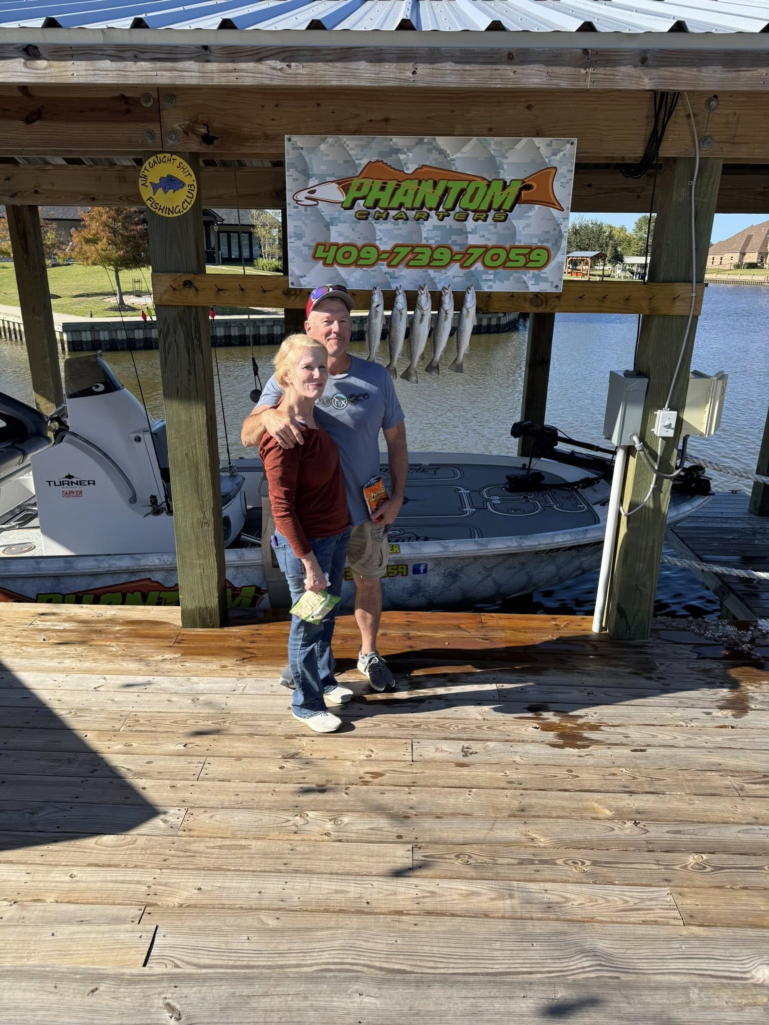 Fishing dock at Bridge City TX with cleaning station displaying caught fish and boat in background