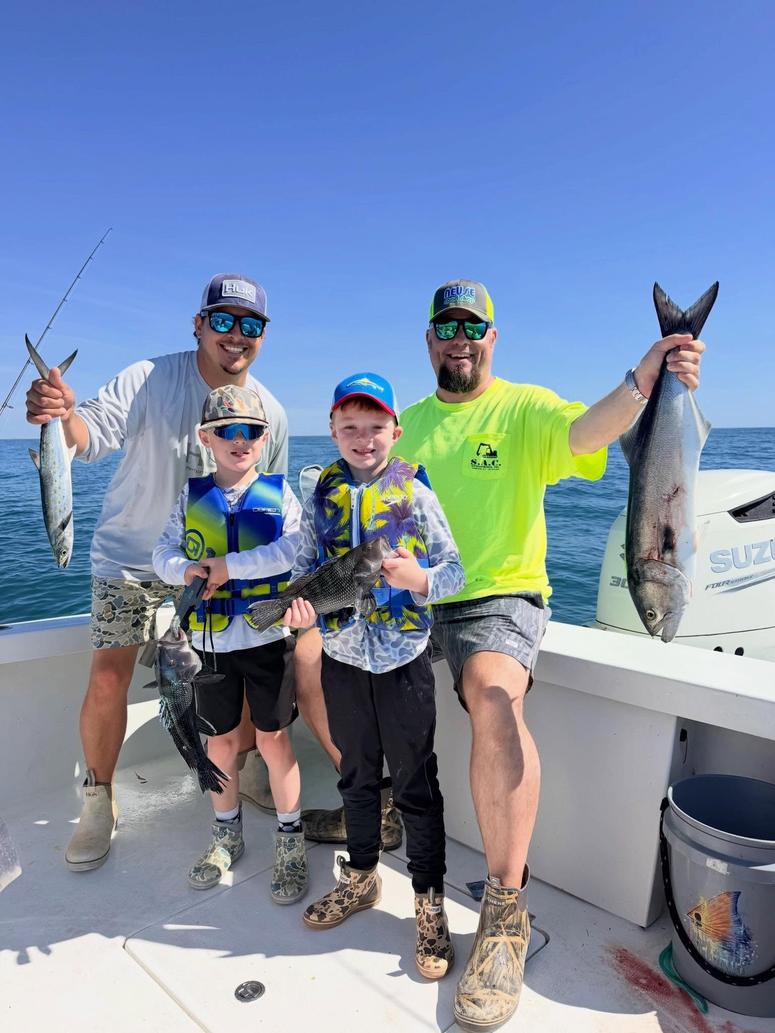 Successful fishing trip in Morehead City NC with bluefish, black sea bass, and spanish mackerel catch displayed on boat deck