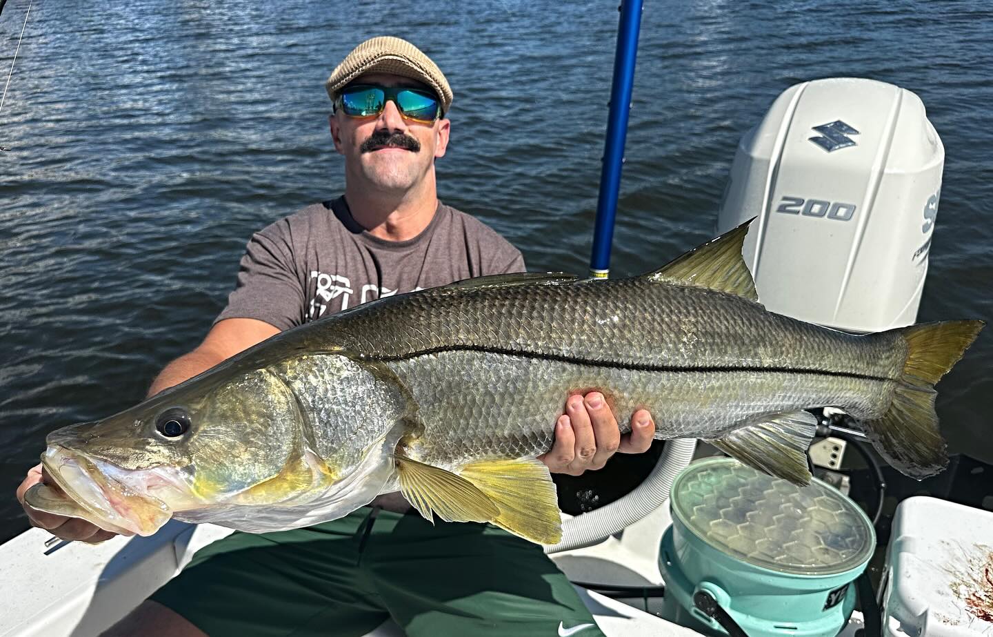 A fisherman holding a large snook catch in Lantana