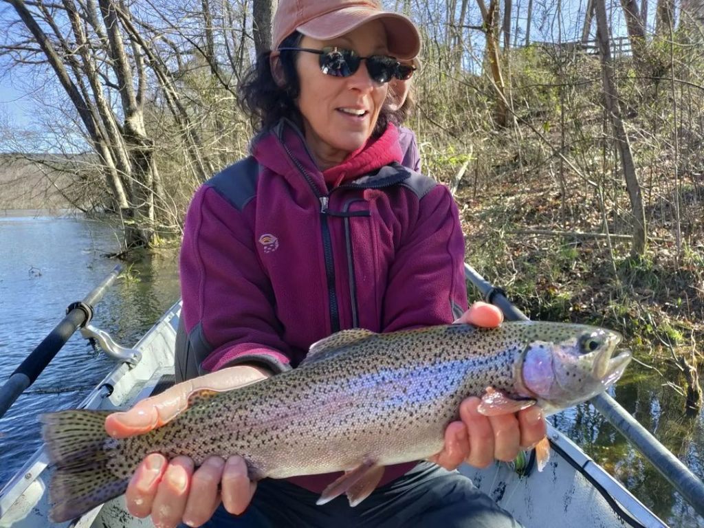 Angler holding a large rainbow trout in AR