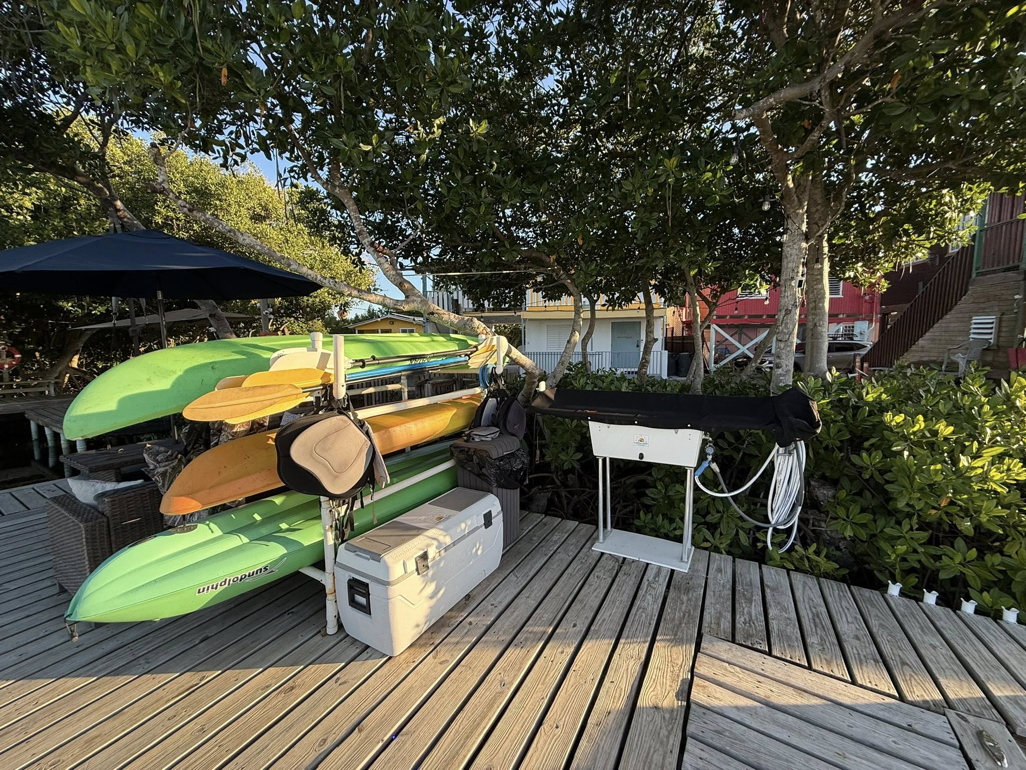 Colorful kayaks and fishing equipment stored on wooden dock in Cabo Rojo PR