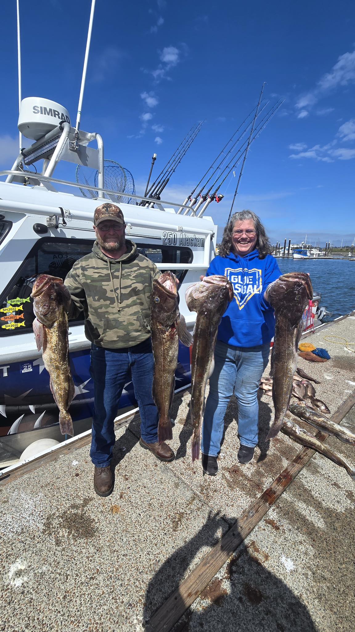 Successful lingcod fishing charter displaying four large lingcod catches on dock in Roseburg OR