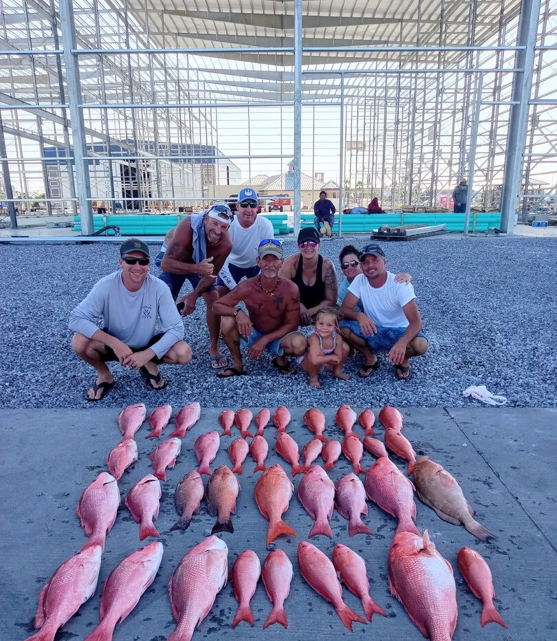 Red grouper fishing catch displayed on dock in Panama City FL with fishing group