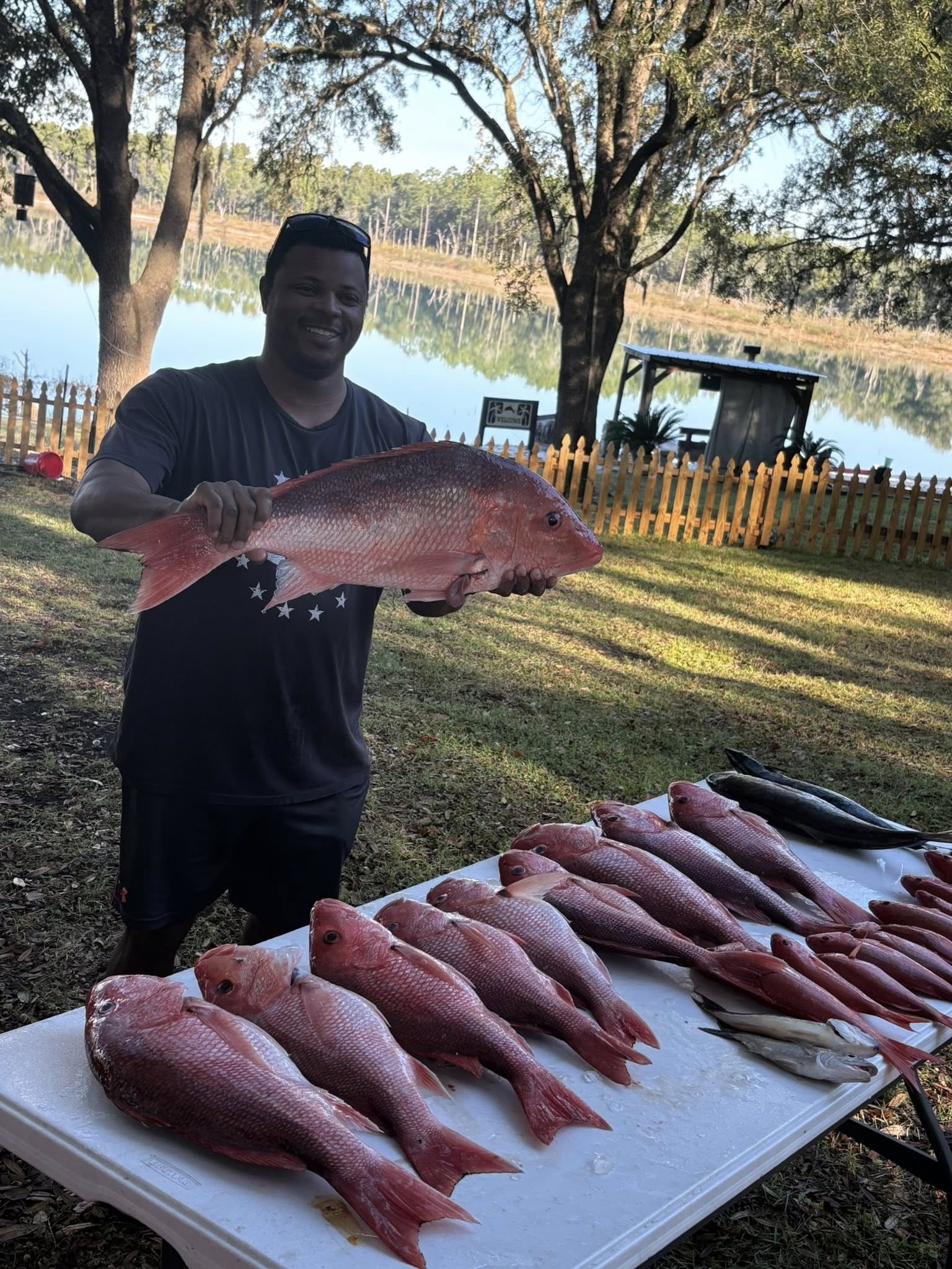 Red snapper fishing catch displayed on table in Panama City FL with angler holding large red snapper