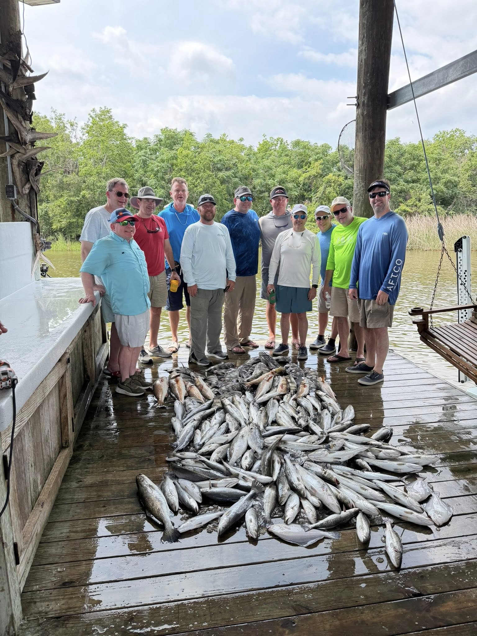Large catch of speckled trout displayed on wooden dock in St Bernard Louisiana after successful fishing trip